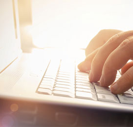 fingers typing on a laptop keyboard